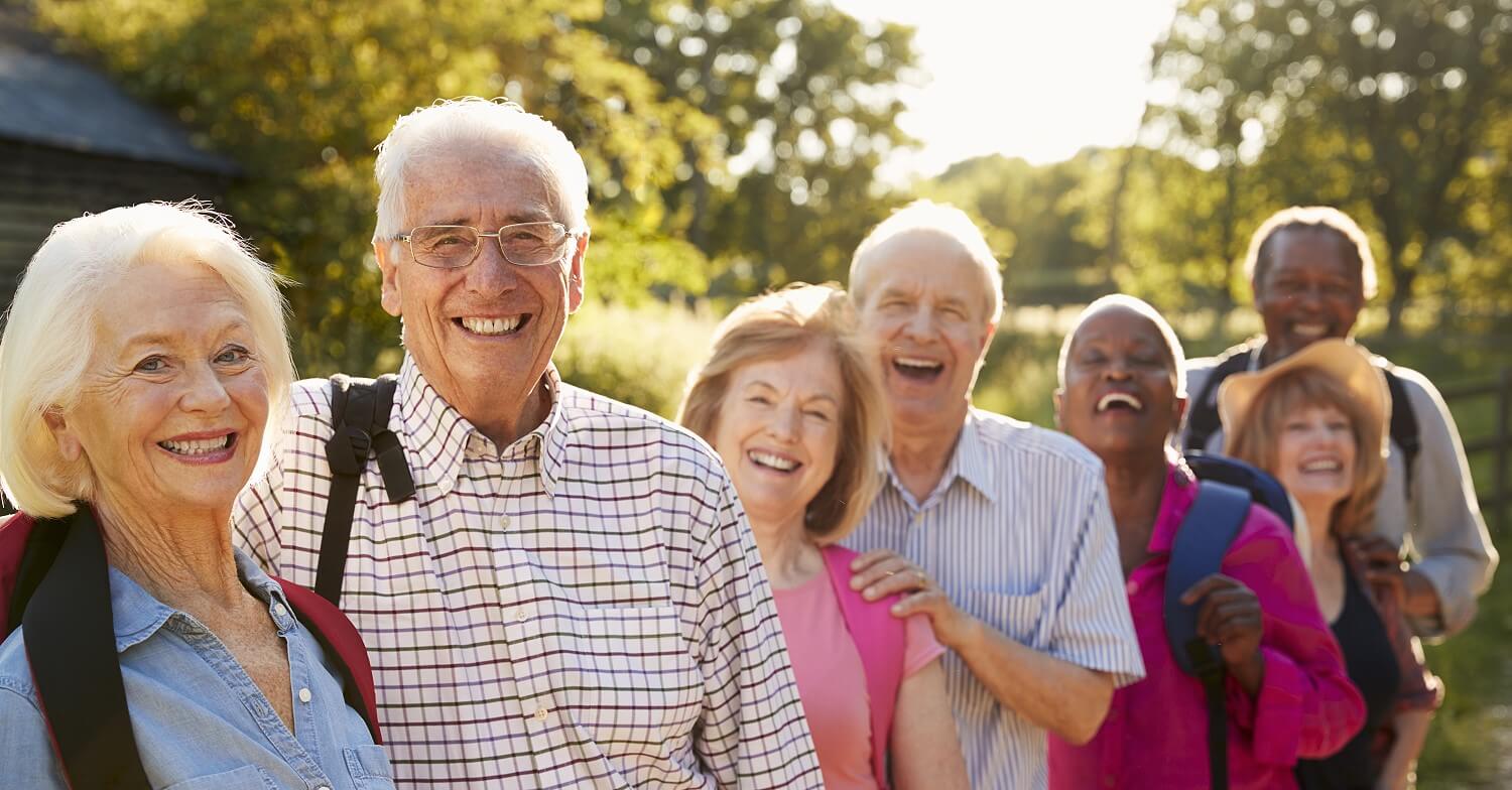 Eine Gruppe Senioren hat sich bei einer Wanderung zum Gruppenfoto aufgestellt