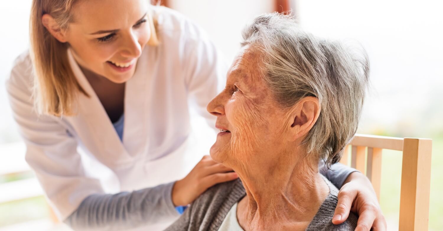 Eine Pflegerin kümmert sich um eine Seniorin